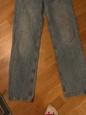 Ljusblå raka jeans från Gina Tricot - Säljer ett par ljusblå raka jeans från Gina Tricot. Klassisk femficksmodell med dragkedja och knapp i midjan. Jeansen har en avslappnad passform och är tillverkade i denim med snygg tvättad look.