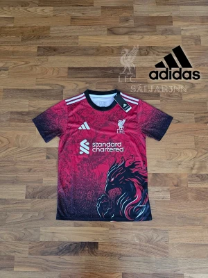 Liverpool Fotbollströja - Liverpool FC Special Edition Fotbollströja – Storlek S Sälj en unik Liverpool FC Special Edition-tröja från Adidas med exklusiv grafisk Liver Bird och detaljer i svart, rött och subtila mönster som skiljer den från vanliga matchtröjor. Perfekt för fans, samlare eller dig som vill sticka ut på planen eller i vardagen. Slim Fit-passform med Adidas Aeroready för komfort. Helt ny med tags kvar. 📦 Snabb leverans – skickas samma dag (om ej hindr.) 📩