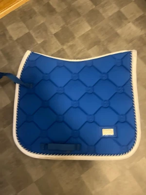 Blått schabrak med vit kant - Storlek cob dressyr schabrak.