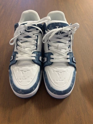 Louis Vuitton blåvita sneakers - Säljer ett par Louis Vuitton sneakers i vitt och blått med klassiskt monogrammönster. Start priset 2500 kr. 