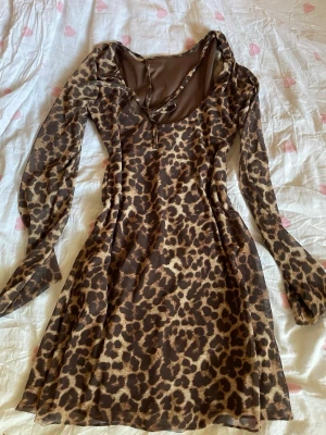 Leopardmönstrad meshklänning - Säljer en snygg leopardmönstrad klänning i mesh med lång ärm och figurnära passform. Klänningen har en djupare ringning och är tillverkad i ett tunt, stretchigt material som ger en cool och trendig look.