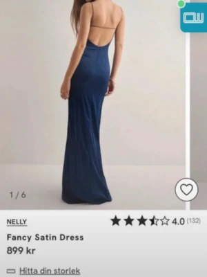 Marinblå långklänning i satin Nelly - Elegant marinblå långklänning från Nelly i glansigt satinmaterial. Klänningen har smala axelband, figurnära passform och öppen rygg. Perfekt för speciella tillfällen där du vill känna dig extra snygg.