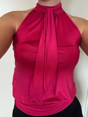 Rosa topp - Topp i satinliknande material med hög hals och knytband. Passar xs-m beroende hur tight man vill ha den.