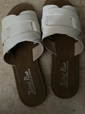 Vita flätade sandaler Ximi Ruo - Säljer ett par vita använda sandaler 