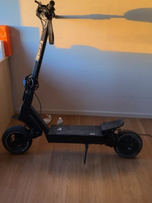 Svart elscooter Kukirin g2 - Säljer en svart elscooter av modellen Kukirin g2 Scootern har robust ram, breda däck och en stadig plattform med halkskydd. Styret är högt och har handtag med bra grepp. Perfekt för dig som vill ta dig fram snabbt och smidigt i stan.