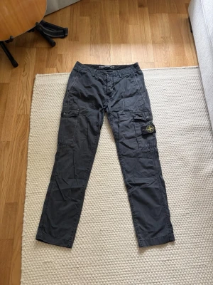 Stone Island cargo - Säljer dessa cargo byxor från stone Island. Byxorna är i mycket bra skick. Nypris: 3699kr Storlek: 29 Mått: Midja i diameter 36cm Total längd 96cm Längd innerben 71cm Benöppning diameter 15,5cm