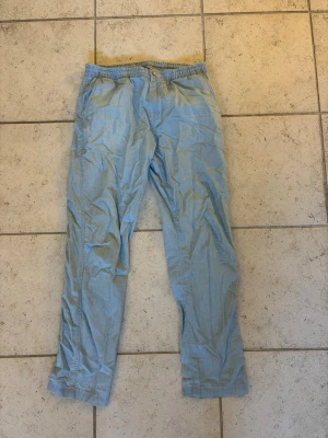 Ljusblå linnebyxor  - Säljer ett par ljusblå linne/bomull blendbyxor från ralph lauren. Byxorna har sidfickor och stängs med knapp och gylf.