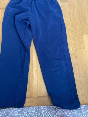 Mörkblå mjukisbyxor med resårmidja - Mörkblå mjukisbyxor med rak passform och resår i midjan. Tillverkade i mjukt och bekvämt material som passar perfekt för chill dagar. Klassisk modell utan synliga loggor eller detaljer.