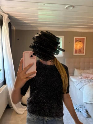 Mörkgrå stickad tröja med glitter från kapphal strl 146/152 - Säljer en mörkgrå stickad tröja med korta ärmar och glittertrådar som ger ett snyggt skimmer. Tröjan har rund halsringning och är i ett mjukt, fluffigt material. Perfekt för dig som vill ha något extra till vardagslooken. Den har använts ungefär 2 gånger så den är i ett väldigt bra skick.