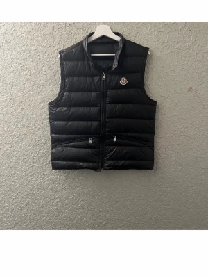 Svart dunväst från Moncler - Snygg väst som är perfekt till sommaren dragkedjan är lite kass som är ett enkel fix för just dig som vill ha en fin väst
