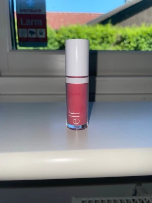 Rosa pigment blush från e.l.f. - Säljer en snygg rosa flytande blush från e.l.f. Kommer i en genomskinlig tub med vit kork och applikator. Perfekt för dig som vill ha en fräsch och pigmenterad look. Enkel att applicera och ger ett jämnt resultat. Går med alla looks!! 🫶🙈