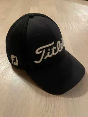 Titleist Onesize keps - Snygg svart golfkeps från Titleist. Den är i storlek L/XL. Mycket bra skick, nästan som ny, inga defekter! Hör av er vid frågor!🔥🤝