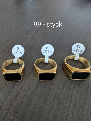 Guldpläterad rostfritt stål ring med svart sten unisex - Stilren guldfärgad ring med rektangulär svart sten på ovansidan. Ringen har en klassisk och modern design som passar perfekt till att lyfta din outfit. Finns i flera storlekar och har en snygg, polerad finish.