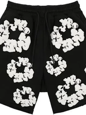 Svarta shorts med blommigt mönster - Svarta shorts med vita blommiga tryck och snörning i midjan. Perfekta för sommaren med avslappnad passform och elastisk midja. Snygg och trendig design som sticker ut.