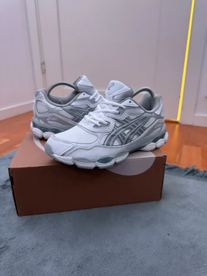 Vit grå Asics gel nyc - Säljer mina Asics då dem var för små på mig. Skorna är som nya och har inga skador eller tecken på användning. 