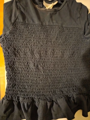 Mörkblå tröja med volangkant - Perfekt för dig som gillar en feminin och trendig stil.