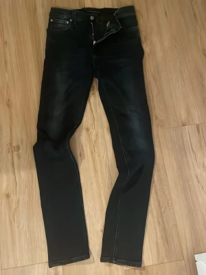 Nudie - Säljer ett par svarta slim fit jeans från Nudie Jeans, bra skick utan defekter, storlek 31:32