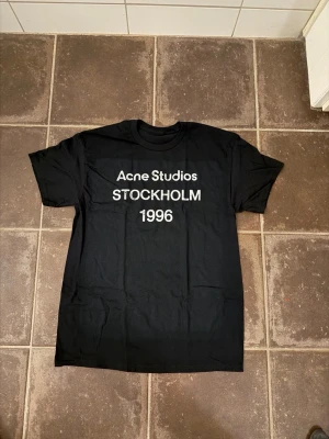 Acne studios t shirt  - Riktigt fet och eftertraktad t shirt med acne studios loggan i storlek M! Helt nytt skick! Lite osäker på äktheten eftersom lappen i nacken saknas så därför är priset just nu på 499kr nypris runt 3000kr! Tveka inte med att ställa frågor! 