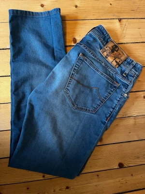Blå jeans från Jacob Cohen - Snygga blå jeans från det exklusiva märket Jacob Cohën. Jeansen är i perfekt skick och har en riktigt snygg ljusblå tvätt kombinerat med en sällsynt patch. Det står att de är i midjestorlek 34 men passar storlek 29/30. Säljer då de inte passar mig längre. Priset är förhandlingsbart, skriv om du har några frågor!