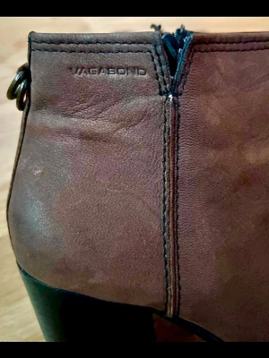 Bruna Vagabond stövletter i läder - Snygga bruna stövletter från Vagabond i läder med markerad söm och dragkedja på sidan. Klackarna är breda och svarta, vilket ger en cool kontrast till det bruna. Insidan är fodrad med ett randigt tyg för extra stilpoäng. Perfekta för dig som gillar klassisk men trendig look.
