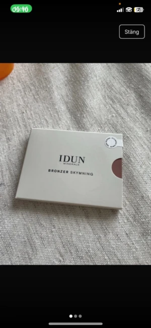 IDUN Minerals Bronzer Skymning - IDUN Minerals Bronzer Skymning är en kompakt bronzer i nyansen Skymning 623. Förpackningen är stilren och rektangulär i beige kartong med ett fönster som visar den varma, bronsiga färgen. Perfekt för att ge ansiktet en solkysst look.