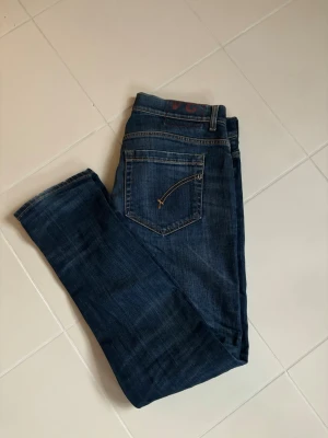Dondup George jeans w34 - Blå snygga populär trendiga stentvättade Dondup George jeans i w34 säljes. 45 cm breda och 100 cm total längd. Sjukt snygga på, grym passform i använt men mycket bra skick så jättefina perfekta nu till våren!