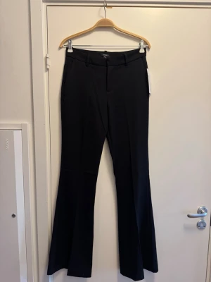 Svarta utsvängda kostymbyxor Lindex - Snygga svarta kostymbyxor från Lindex med utsvängda ben och medelhög midja. Byxorna har hällor för skärp och fickor i sidorna. Perfekta för långa personer då det är en tall modell så benen är extra långa. Innerbenslängden är 86 cm. De är storlek 36 och aldrig använda, nypris 599 kr. Pris kan diskuteras vid snabb affär och skriv om du har andra frågor🥰