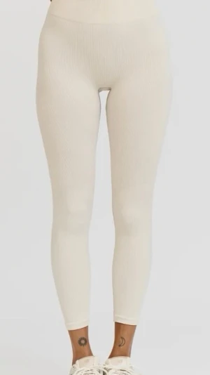 Ribbade beige leggings från H&M - Säljer ett par ribbade leggings i beige. De har hög midja och är tillverkade i ett mjukt, stretchigt material som sitter skönt på kroppen. Perfekta att matcha med en oversized hoodie eller crop top för en chill look.