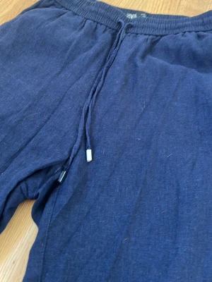Mörkblå linnebyxor från ZARA - Mörkblå linnebyxor från ZARA med raka ben och elastisk midja med dragsnöre. Fina att ha på sommaren i varma väder 