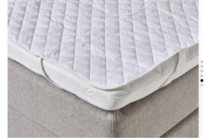 Vitt madrasskydd med resårband - Säljer ett vitt madrasskydd med quiltat mönster och praktiska resårband i hörnen som håller skyddet på plats. Tillverkat i mjukt tyg, perfekt för att skydda madrassen och ge extra komfort. Passar de flesta sängar och är lätt att tvätta.