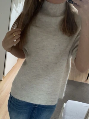 Begie stickad polotröja - Mysig ljusgrå stickad tröja med hög polokrage och korta ärmar. Tröjan har en avslappnad passform och är perfekt att styla med jeans. Från gina tricot och tröjan är i storlek xs.❤️
