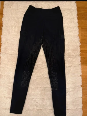 Svarta ridbyxor med mönstrat grepp - Säljer ett par svarta ridbyxor från zaczess med hög midja och helskodda partier med cirkelmönstrat grepp. Byxorna har fickor på sidorna och är tillverkade i stretchigt material som passar perfekt för ridning. Storlek xxs men passar S-xxs 