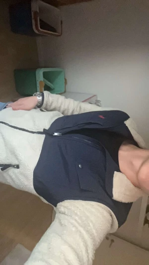 Beige teddyjacka med blå detaljer - Säljer en beige teddyjacka med marinblå detaljer på axlar och bröst. Jackan har dragkedja framtill, bröstficka med knapp och mjukt, fluffigt material. Perfekt för dig som vill ha myskänsla och stil i ett. 