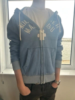 Blå zip hoodie Hollister Malibu - En riktigt fet hollister tröja! Sitter lite för stor, stl L/M och har fint skick. Skick:9/10 | modellen är 185cm lång. Pris 599 men kan diskuteras🤩🤩
