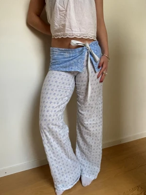 Vita och blå low waist byxor med knyt - Säljer dessa fantastiska byxor!! 💕💕De är lågmidjade, sydda i ett mönstrat tyg av bomull. De är sydda av mig och är därför helt unika! Likande dom från beshka. Passar ca s, jag är 162 cm. Har ett snöre i midjan där man kan spänna in, men de är inte stretchig så kan vara svåra att få på sig. Ställ gärna frågor och kika gärna på mina andra annonser! Kommer även ladda upp fler saker jag sytt till våren/sommaren, så följ gärna. 💗