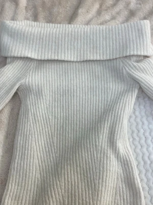 Off shoulder stickad tröja H&M - Säljer en ribbstickad off shoulder-tröja från H&M i ljusbeige. Tröjan har bred krage som viks ner över axlarna och är figurnära i modellen. Perfekt för dig som gillar en trendig och stilren look.