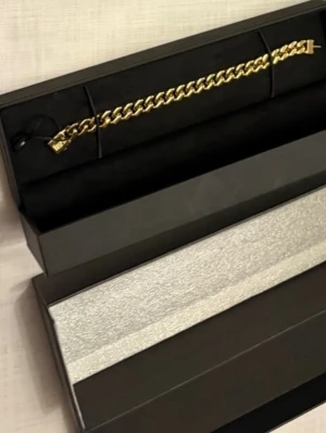 Guldfärgat kedjearmband från Kjeser - Snyggt guldfärgat armband från Kjeser med klassisk kedjedesign. Armbandet har en blank finish och ett diskret Kjeser-märke vid låset. Perfekt accessoar för dig som gillar stilrena och trendiga smycken. Levereras i elegant presentask.