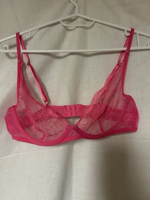 Rosa spets-bh med bygel - Säljer en snygg rosa bh med tunna, transparenta spetskupor och justerbara axelband.  Är ganska säker på att den är från hunkmöller, men jag har klippt av lappen (då den skavde, de FÅ gånger jag använde den). Jag chansa på storleken, så om du är osäker får du gärna fråga om mått 