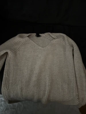 Beige stickad tröja med strukturmönster - Snygg beige stickad tröja med strukturmönster och rund halsringning. Perfekt för lager-på-lager och passar till många olika stilar. Tröjan har en klassisk passform och ribbade detaljer vid halsen.