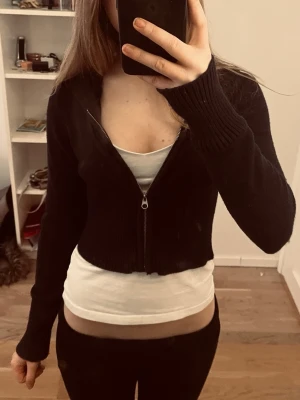 Svart croppad hoodie med dragkedja - Snygg mörk blå croppad hoodie med dragkedja från Gina. Hoodien har en klassisk huva och är tillverkad i ett mjukt stickat material. Den är lite nopprig vilket är varför jag säljer den för lite billigare, skriv för mer bilder eller andra frågor 💓 pris är diskuterbart!