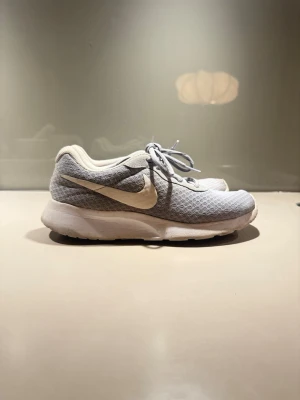 Nike gråvita mesh sneakers - Snygga sneakers från Nike i grått och vitt! Skorna har vita snören, röd innersula och en bekväm, tjock sula som passar perfekt till en sportig och avslappnad stil.