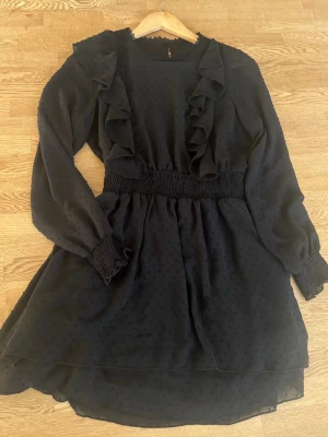 Svart kortklänning - Svart kortklänning med lite volanger och detaljer🖤använd 1 till 2 gånger men är i jättebra skick💕