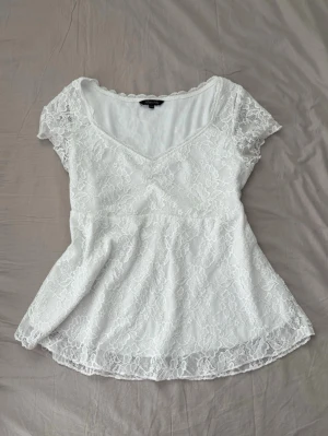 Vit spetstopp - Söt vit topp med v-ringning och korta ärmar. Mycket bra skick och säljer endast för att den var lite för stor på mig! 