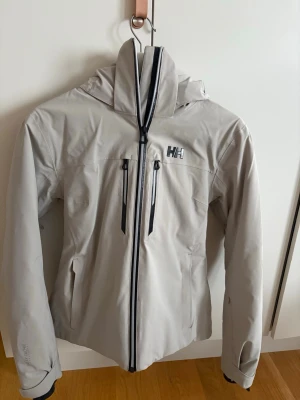 Helly Hansen skidjacka och skidbyxor - Säljer en skidjacka och ett par skidbyxor från helly Hansen. Byxor är aldirg använda och har lappen kvar. Jackan är endast använd en skidsäsong och är i nyskick. Man kan köpa dem tillsammans för 2000kr och annars jackan för 1500 och byxorna för 1200kr! S i både jackan och byxan!