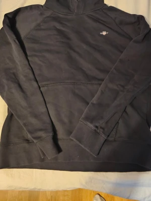 Svart hoodie Gant - Snygg svart hoodie från Gant med liten broderad logga på bröstet. Strl 176