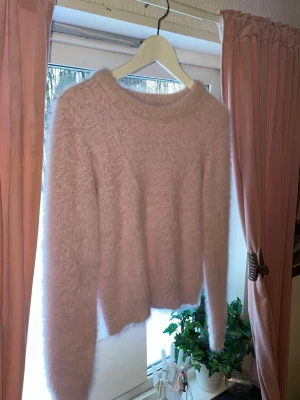 Ljusrosa fluffig stickad tröja - Supersöt ljusrosa stickad tröja från Samsa Young, jag köpte den på gekås! Tröjan är fluffig och har väldigt mjukt och skönt material. Jätte fin och passar dig som gillar mer mjuka/bekväma kläder att ha en vardag💕den är i storlek 170 (barnstorlek) jag har storlek S i vanliga fall den passar mig!