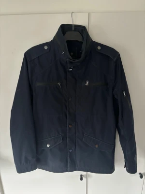 Riley fieldjacket M - Denna stört snygga unika blåa Riley field jackan i storlek 50 (M) säljes. Använt men bra skick! Högkvalitativ otrolig jacka från brothers med nypris på över 2000 kr