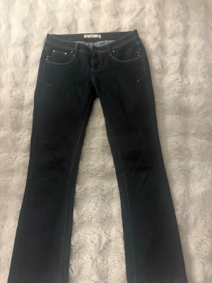 Mörkblå bootcut jeans med vita sömmar  - Snygga mörkblå bootcut jeans med vita kontrastsömmar ifrån joom i storlek S!💗  I modellen är de bootcut och lågmidjade. Köpt vinted men mycket bra skick, jag själv har inte använd de!💗💗