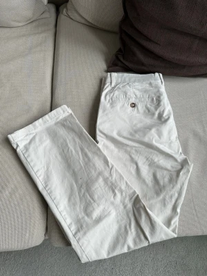 Vita raka chinos med fickor - Snygga vita chinos med rak passform och klassiska fickor både fram och bak.  Perfekta för en clean och stilren look. 