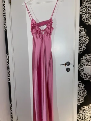 Rosa satin klänning med volangdetaljer Zara - Rosa klänning i satin med smala axelband och volangdetaljer vid bysten. 